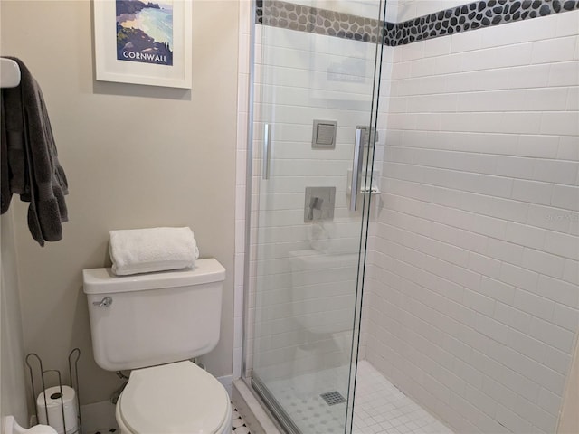 bathroom with a shower with door and toilet