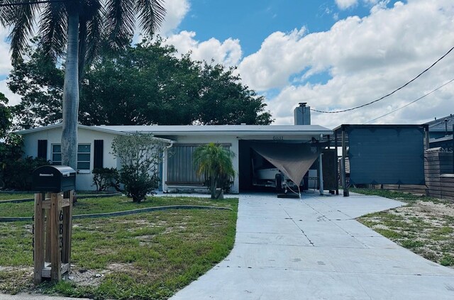 ranch-style home with a carport and a front yard