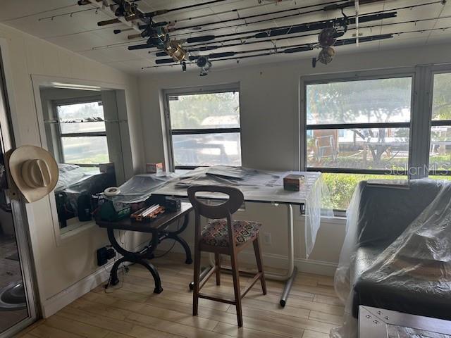 dining area featuring light wood finished floors and vaulted ceiling