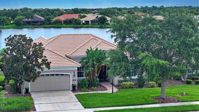 exterior space with a garage, a water view, and a front yard