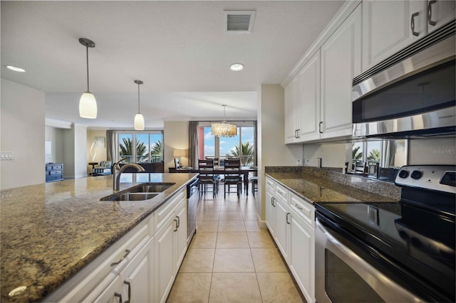 kitchen with white cabinetry, sink, stainless steel appliances, and dark stone countertops