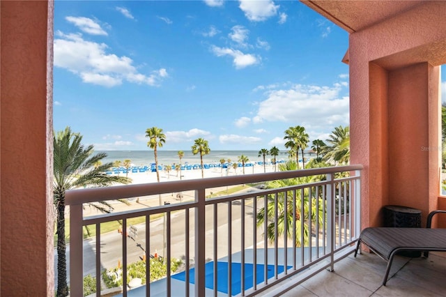 balcony featuring a water view and a beach view