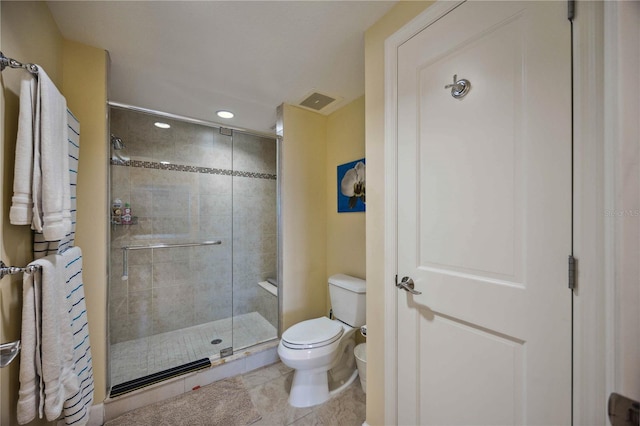 bathroom featuring toilet, tile patterned floors, and an enclosed shower