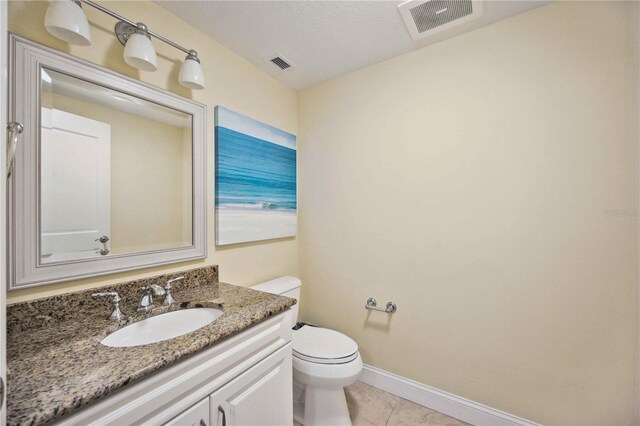 bathroom with tile patterned floors, vanity, and toilet