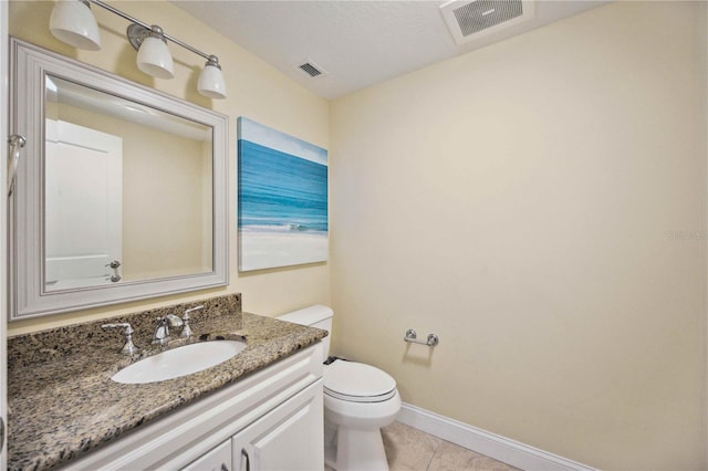 bathroom featuring vanity, tile patterned floors, and toilet