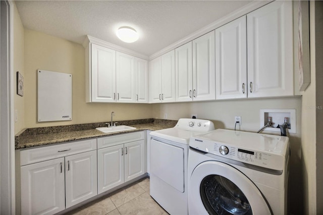 clothes washing area featuring sink, cabinets, light tile patterned floors, and independent washer and dryer