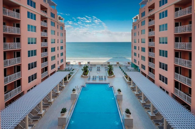 view of swimming pool with pool water feature and a water view