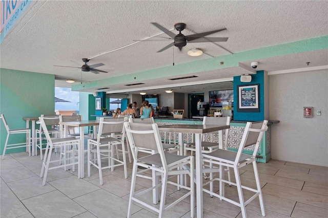 dining room with ceiling fan and a textured ceiling