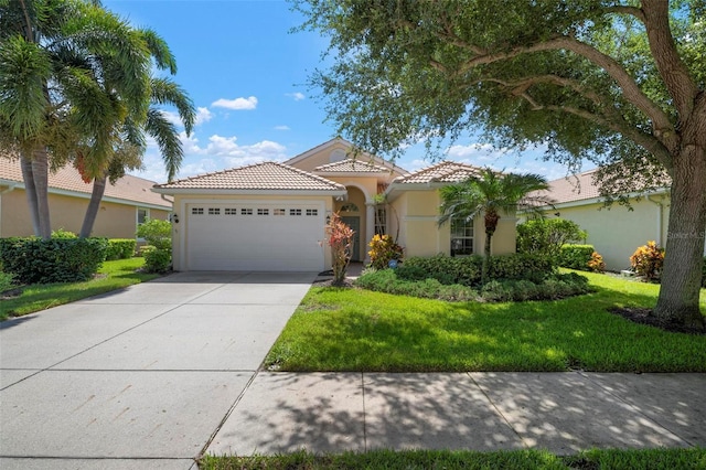 mediterranean / spanish house featuring a garage and a front yard