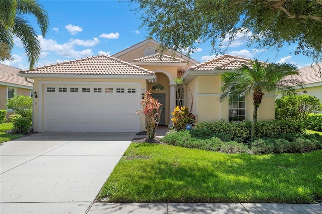 mediterranean / spanish house featuring a garage and a front lawn