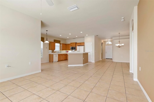 unfurnished living room featuring ceiling fan with notable chandelier and light tile patterned floors