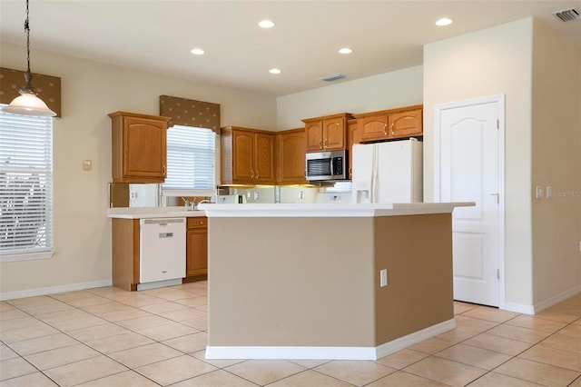 kitchen featuring pendant lighting, light tile patterned floors, a kitchen island, and white appliances