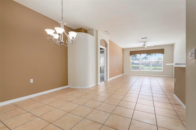 tiled empty room with ceiling fan with notable chandelier