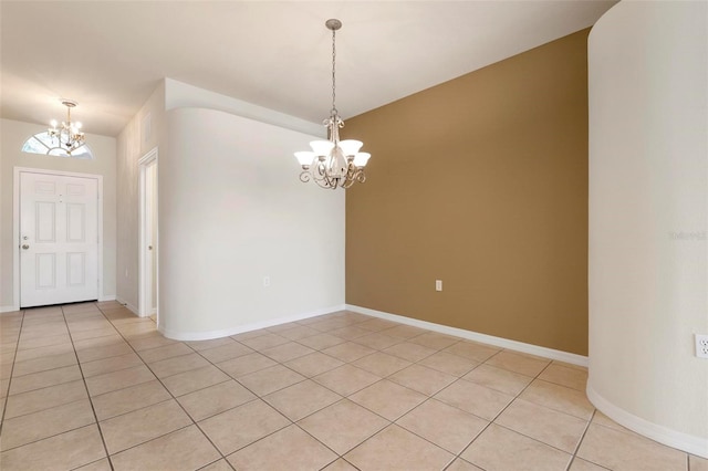 tiled empty room with an inviting chandelier