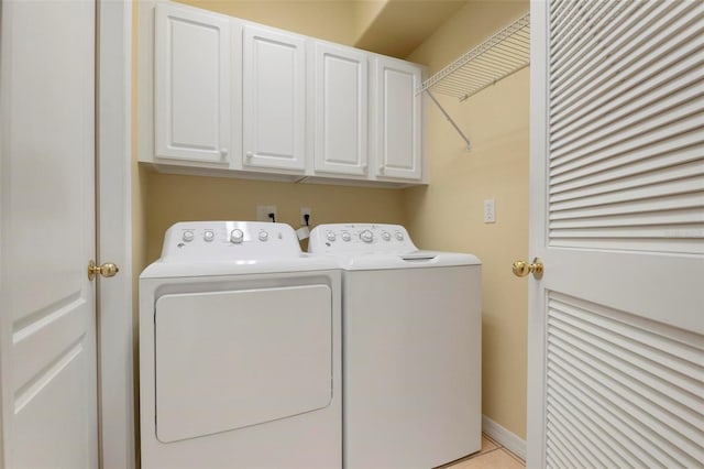 washroom featuring light tile patterned flooring, separate washer and dryer, and cabinets