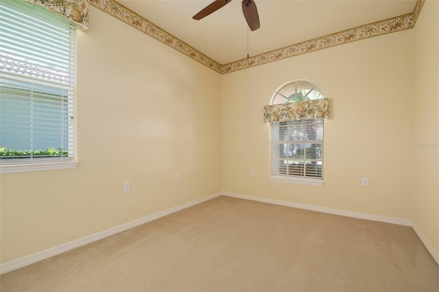 carpeted spare room featuring ceiling fan