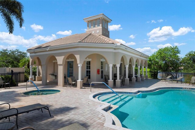 view of pool with a patio and a hot tub