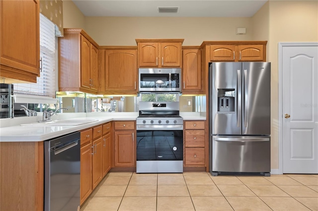 kitchen with appliances with stainless steel finishes, sink, and light tile patterned floors