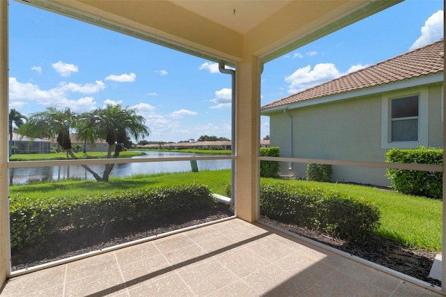 unfurnished sunroom featuring a water view