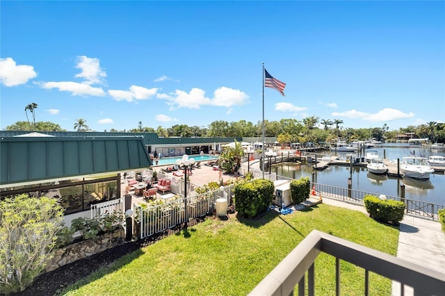 exterior space featuring a boat dock, a water view, and a fenced in pool