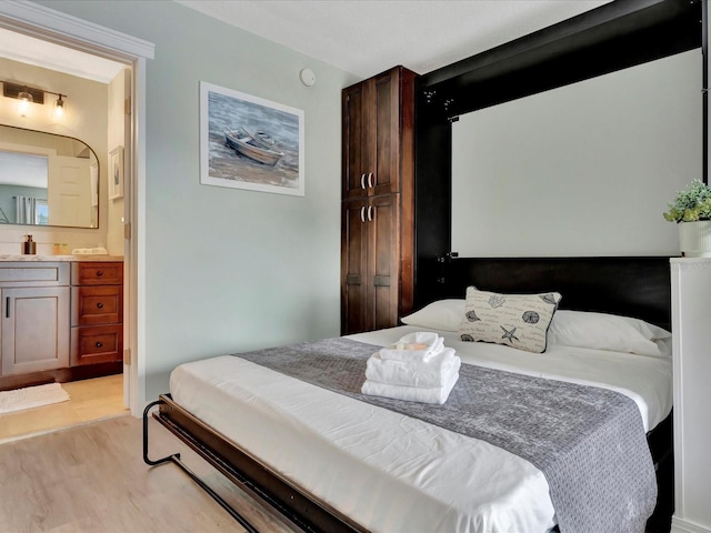 bedroom featuring light hardwood / wood-style floors and ensuite bathroom