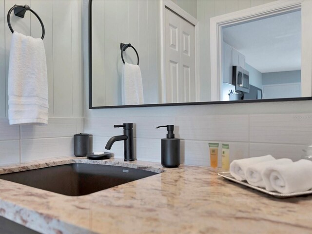 bathroom with sink and decorative backsplash