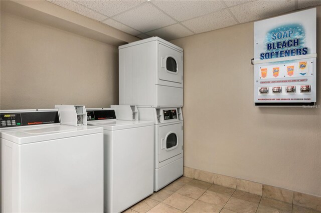 washroom featuring light tile patterned flooring and stacked washer / drying machine