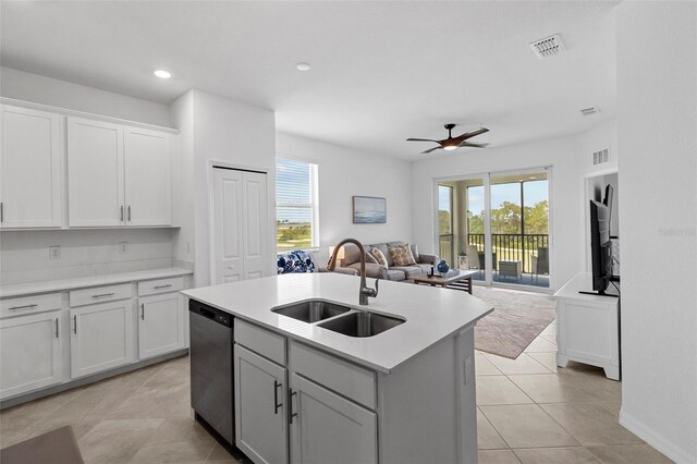 kitchen with ceiling fan, sink, stainless steel dishwasher, a center island with sink, and a healthy amount of sunlight