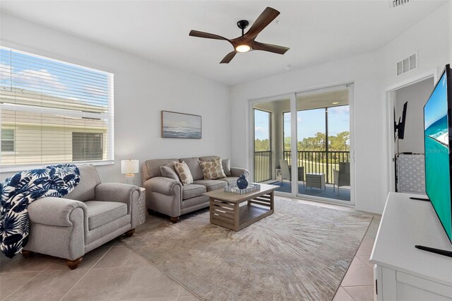 tiled living room featuring a healthy amount of sunlight and ceiling fan