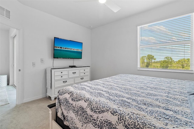 bedroom featuring light carpet, baseboards, multiple windows, and visible vents