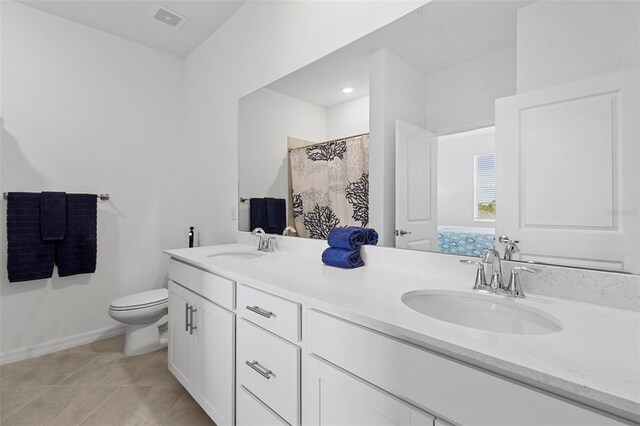 bathroom featuring tile patterned flooring, vanity, and toilet