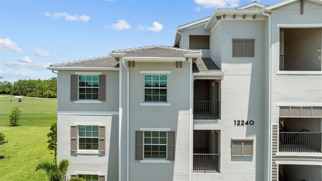 exterior space with a balcony and a lawn