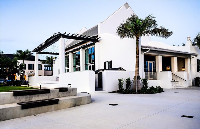 exterior space featuring a pergola and stucco siding