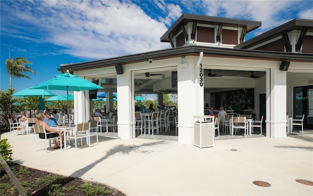 view of patio with outdoor dining area, fence, and ceiling fan