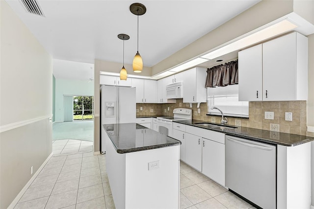 kitchen featuring sink, white appliances, white cabinets, and a center island