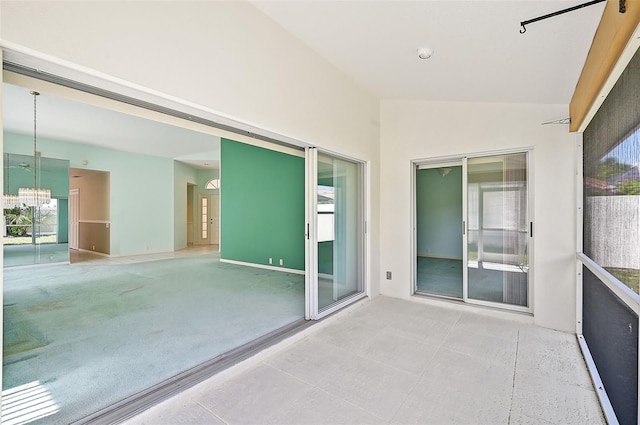 unfurnished sunroom with vaulted ceiling and a chandelier