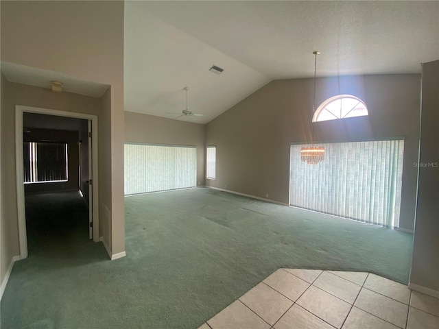 interior space with ceiling fan, high vaulted ceiling, visible vents, baseboards, and tile patterned floors