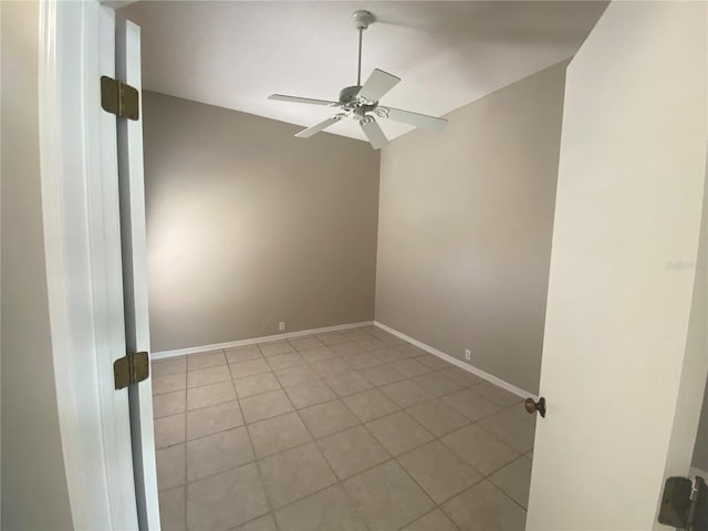 unfurnished room with lofted ceiling, light tile patterned floors, baseboards, and a ceiling fan