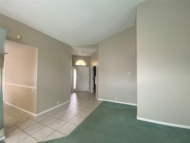 entrance foyer with light colored carpet, light tile patterned flooring, and baseboards