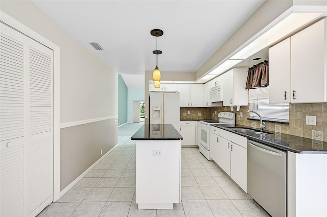 kitchen with white appliances, light tile patterned floors, white cabinets, and a sink