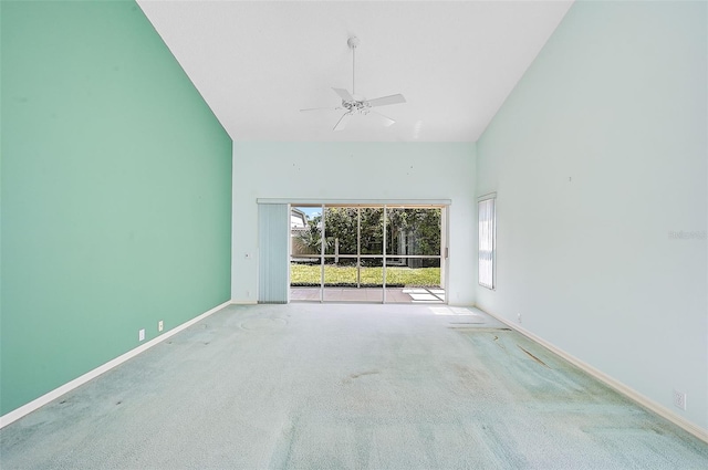 carpeted spare room with high vaulted ceiling, ceiling fan, and baseboards