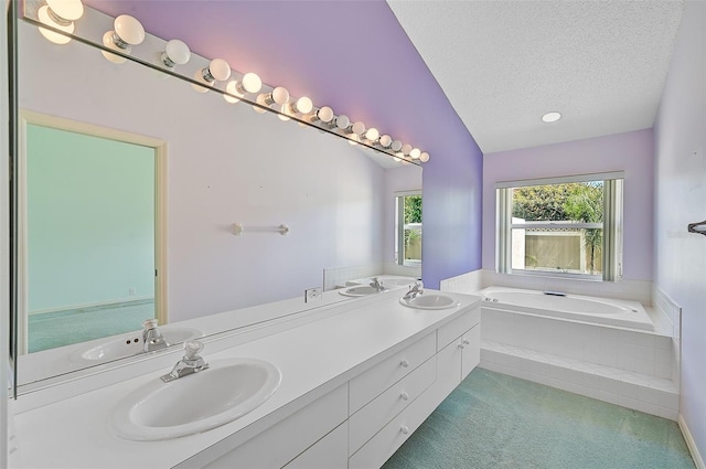 full bathroom with a textured ceiling, double vanity, a sink, and a bath