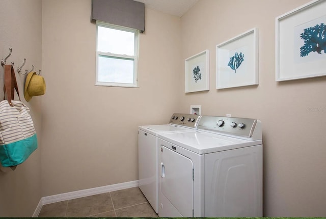 clothes washing area with light tile patterned flooring and washer and clothes dryer