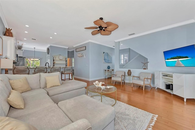 living room with ceiling fan, light hardwood / wood-style flooring, and ornamental molding