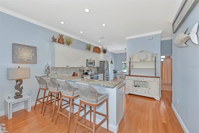 kitchen featuring appliances with stainless steel finishes, white cabinets, and light wood-type flooring