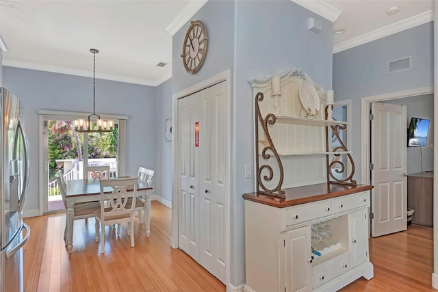 kitchen featuring light hardwood / wood-style flooring, crown molding, stainless steel refrigerator with ice dispenser, white cabinetry, and a notable chandelier