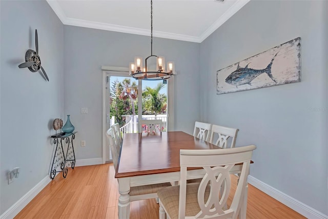 dining area featuring an inviting chandelier, light wood-type flooring, and ornamental molding