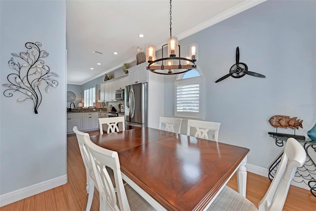 dining area featuring ceiling fan with notable chandelier, ornamental molding, light hardwood / wood-style flooring, and a wealth of natural light