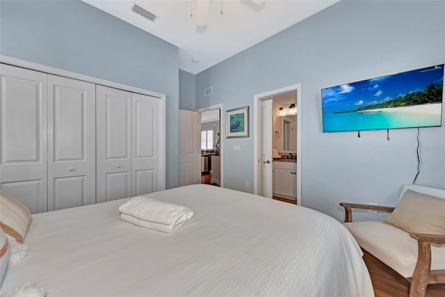 bedroom featuring ensuite bath, ceiling fan, a closet, and wood-type flooring