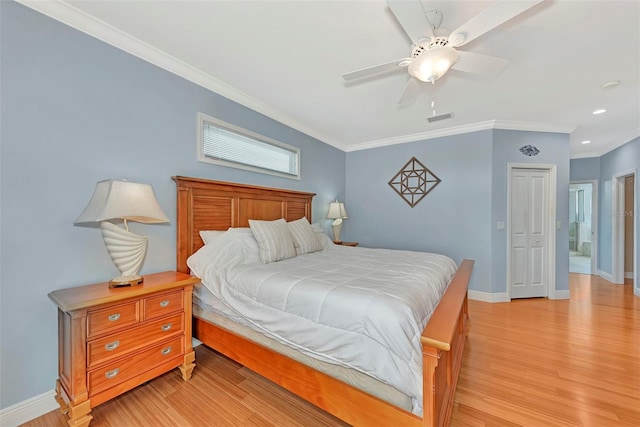 bedroom with light wood-type flooring, ceiling fan, ornamental molding, and a closet